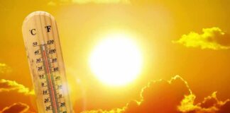 thermometer in front of a blazing sun and orange sky