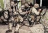 Trump-Era Push Turbocharges Robot Logistics soldiers in camouflage gear take positions inside a damaged building