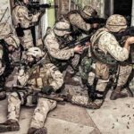 Trump-Era Push Turbocharges Robot Logistics soldiers in camouflage gear take positions inside a damaged building