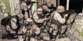 soldiers in camouflage gear take positions inside a damaged building