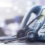 258 Nabbed in Call-Center Crackdown Headset resting on an office desk phone