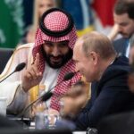 Two delegates converse at an international summit table