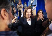 Awkward Omission Torches Dem Unity Woman in black blazer speaking animatedly to a crowd
