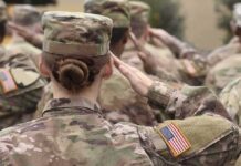 U.S. soldiers in camouflage uniforms saluting