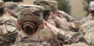 U.S. soldiers in camouflage uniforms saluting