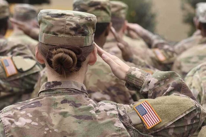 shutterstock_1711680580 U.S. soldiers in camouflage uniforms saluting