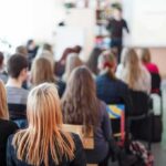 Campus Shock: Tenure Hinges on Ideology Students seated in a classroom listening to a presentation