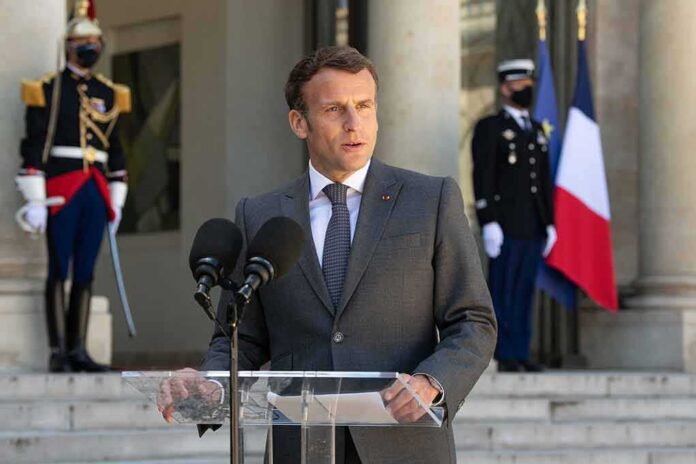 shutterstock_1997933435 man in suit speaking at podium with microphones