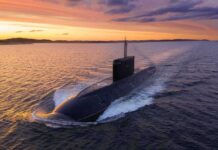 Budget Gambit: Steel-Built Submarines Win Submarine cruising on the surface at sunset