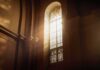sunlit stained glass window in a church interior
