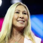Smiling blonde woman speaking on stage