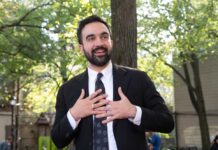 Court Twist Keeps Costly Surcharge Alive Man in suit speaking with hands on chest outdoors