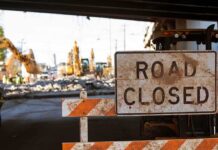Road closed sign at construction site under overpass