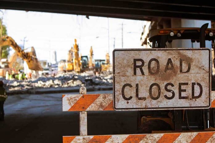 Road closed sign at construction site under overpass
