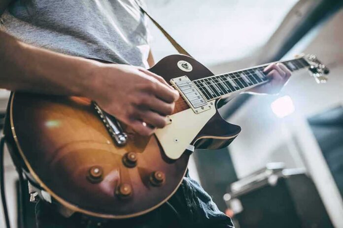 shutterstock_740713315 Guitarist playing a sunburst electric guitar