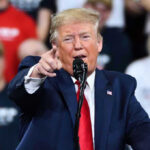 Trump Slaps ‘Fake News’—On-Camera Takedown Rattles CNN Man in suit pointing, speaking at a rally.