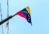Brain Drain Guts Venezuela’s Comeback Venezuelan flag flying on a pole.