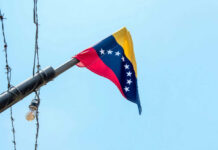 Brain Drain Guts Venezuela’s Comeback Venezuelan flag flying on a pole.