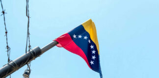Venezuelan flag flying on a pole.