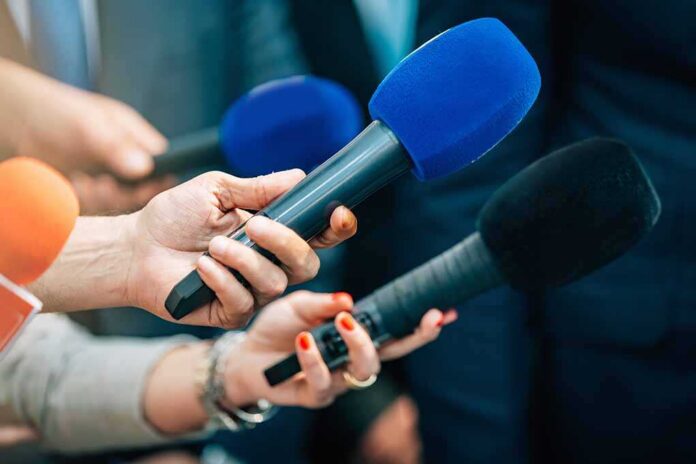 Reporters holding colorful microphones