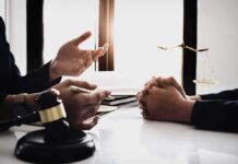 Lawyer consulting client at desk with gavel and scales