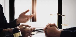 Lawyer consulting client at desk with gavel and scales