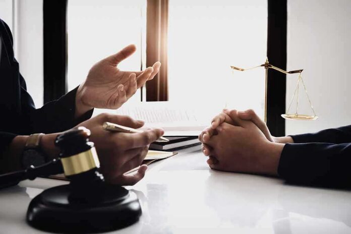 shutterstock_1095575156 Lawyer consulting client at desk with gavel and scales