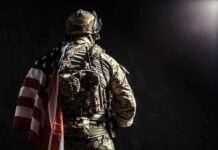 Soldier in tactical gear with American flag over shoulder