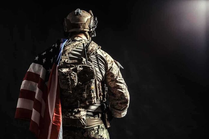 Soldier in tactical gear with American flag over shoulder