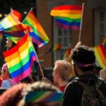 Alberta Clash: Court Fight Looms Over Kids’ Care Crowd waving rainbow flags at an outdoor event
