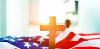Wooden cross on an American flag