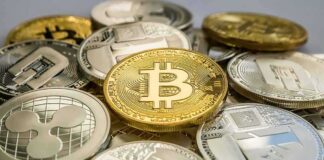 Stack of assorted cryptocurrency coins with a gold bitcoin in the center