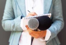 Journalist holding microphones and notepad
