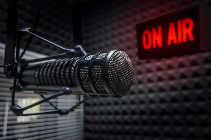 shutterstock_1218528058 Close-up of a studio microphone with an illuminated on-air sign