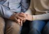 Custody Chaos Over Pronouns – Parental Rights Flashpoint Erupts Couple holding hands on a couch