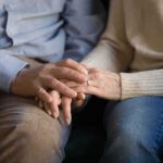 Custody Chaos Over Pronouns – Parental Rights Flashpoint Erupts Couple holding hands on a couch