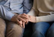 Custody Chaos Over Pronouns – Parental Rights Flashpoint Erupts Couple holding hands on a couch