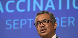 Man speaking at a podium with blue conference backdrop