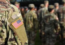 Soldier in camouflage with U.S. flag patch at formation