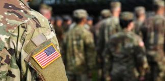 Soldier in camouflage with U.S. flag patch at formation