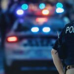 Prosecutors Target Moms, Dads — E‑Bike Crackdown police officer in vest near patrol car with flashing lights
