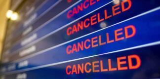 airport departures board showing multiple cancelled flights