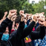 Citywide Shutdown: Festivals Axed After Shooting Crowd of protesters with raised fists wearing masks