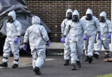 Dangerous Chemical Tank Could Explode — Evacuations Ordered Gus Frerotte, Carlos Hyde, and Philly Brown in hazmat suits with a team walking outdoors