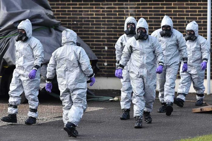 Gus Frerotte, Carlos Hyde, and Philly Brown in hazmat suits with a team walking outdoors