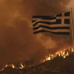 Power Threat Claim Explodes in Greece – Denial Fuels Bigger Mystery Greek flag over hillside wildfire