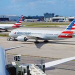 American Airlines jets taxi at a busy airport apron
