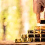 Staggering Haul: CIA Gold Hoard Triggers Plea Hand stacking small gold bars into a pyramid