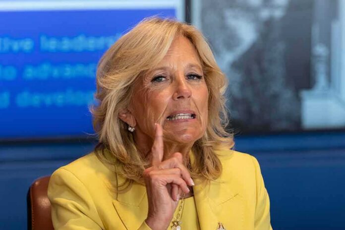 woman in yellow blazer gesturing with raised index finger