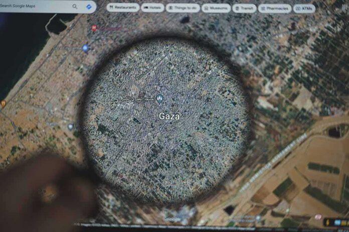 Magnifying glass highlighting Gaza on a digital map